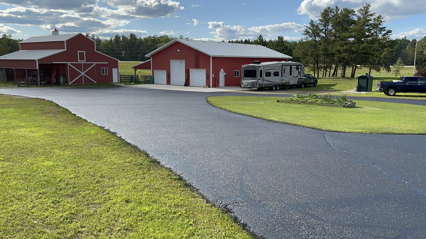 Fresh asphalt driveway paving on rural Minnesota farm property